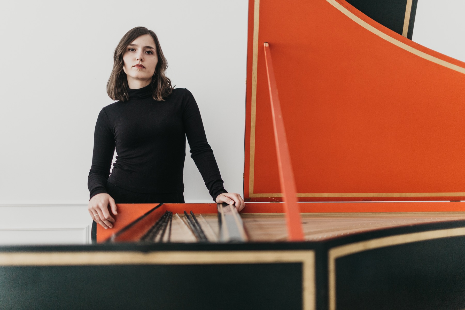 Gosia Klajn standing behind a harpsichord